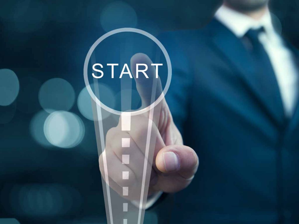 Een zakenman die op een knop met start drukt.