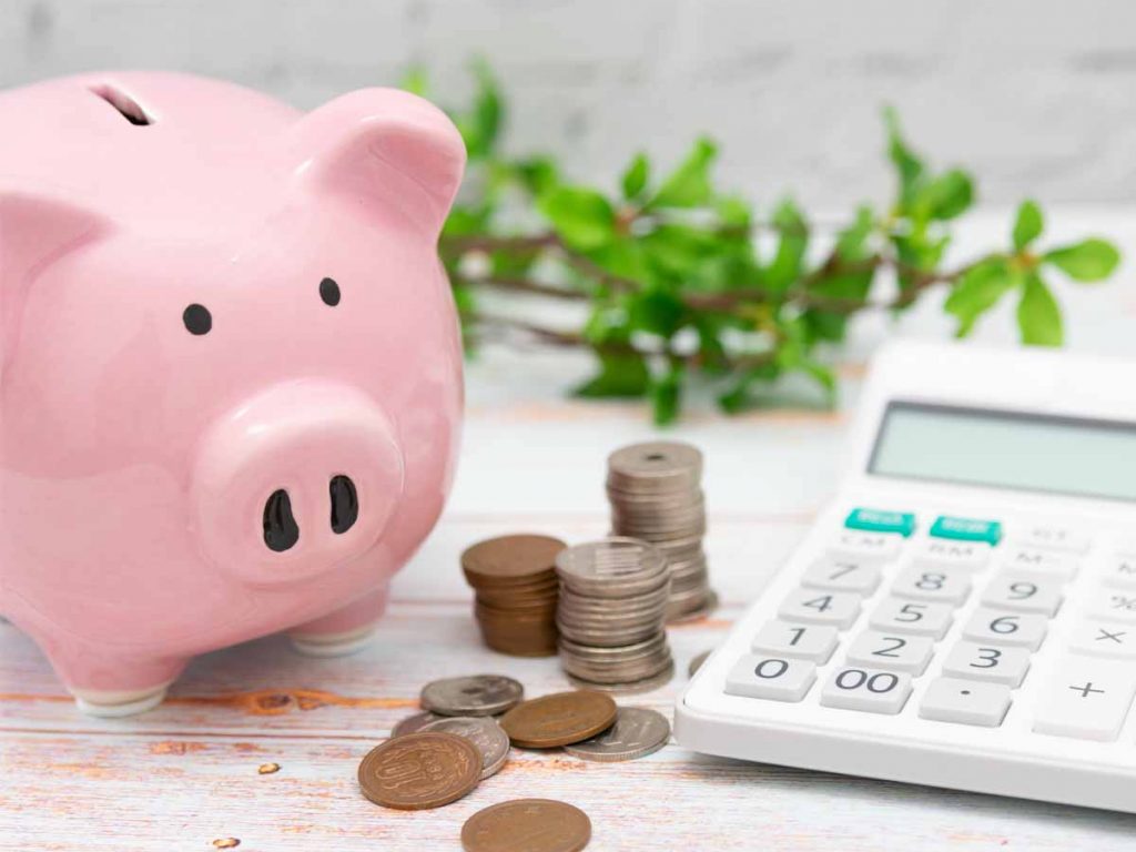 Spaarvarken met geld en een rekenmachine.