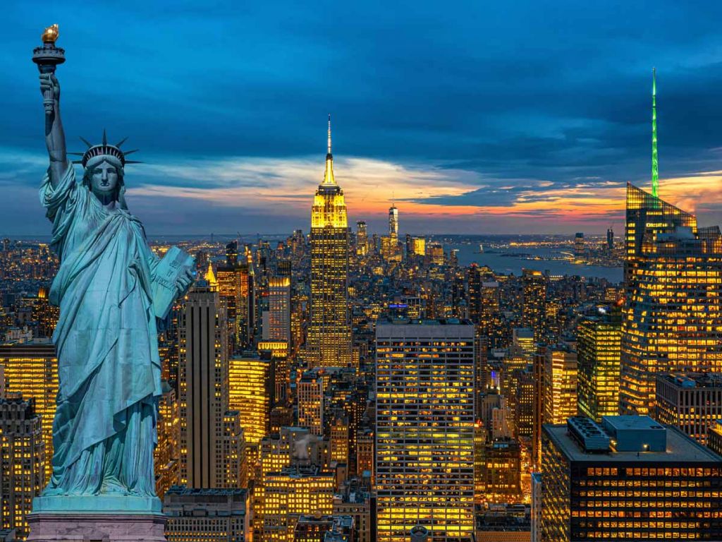 Een Amerikaanse stad met het vrijheidsbeeld ervoor.