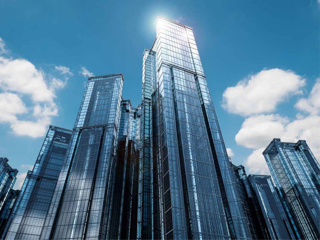 Een aantal wolkenkrabbers in een blauwe lucht met witte wolken..